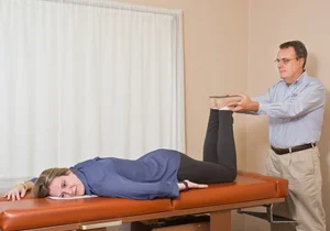 Dr. Lefebvre examining leg movement as part of a chiropractic visit
